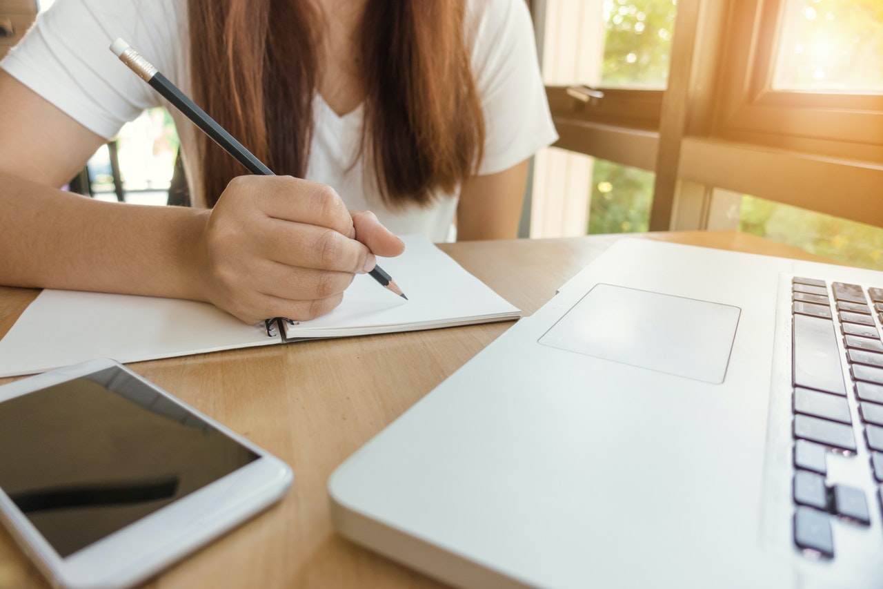 girl taking study note on a desk chatsifieds learn english faster