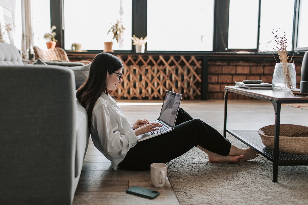 Young woman siting on the floor and study live English lessons on her lap chatsifieds easy english